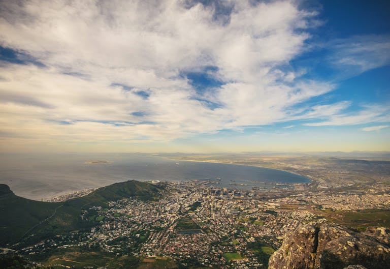 Stunning aerial view of Cape Town with the coastline, mountains, and blue sky.